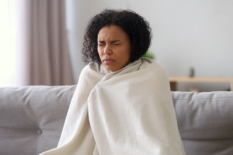 Image of person wrapped in blanket. Video - Upgrade Your Furnace.